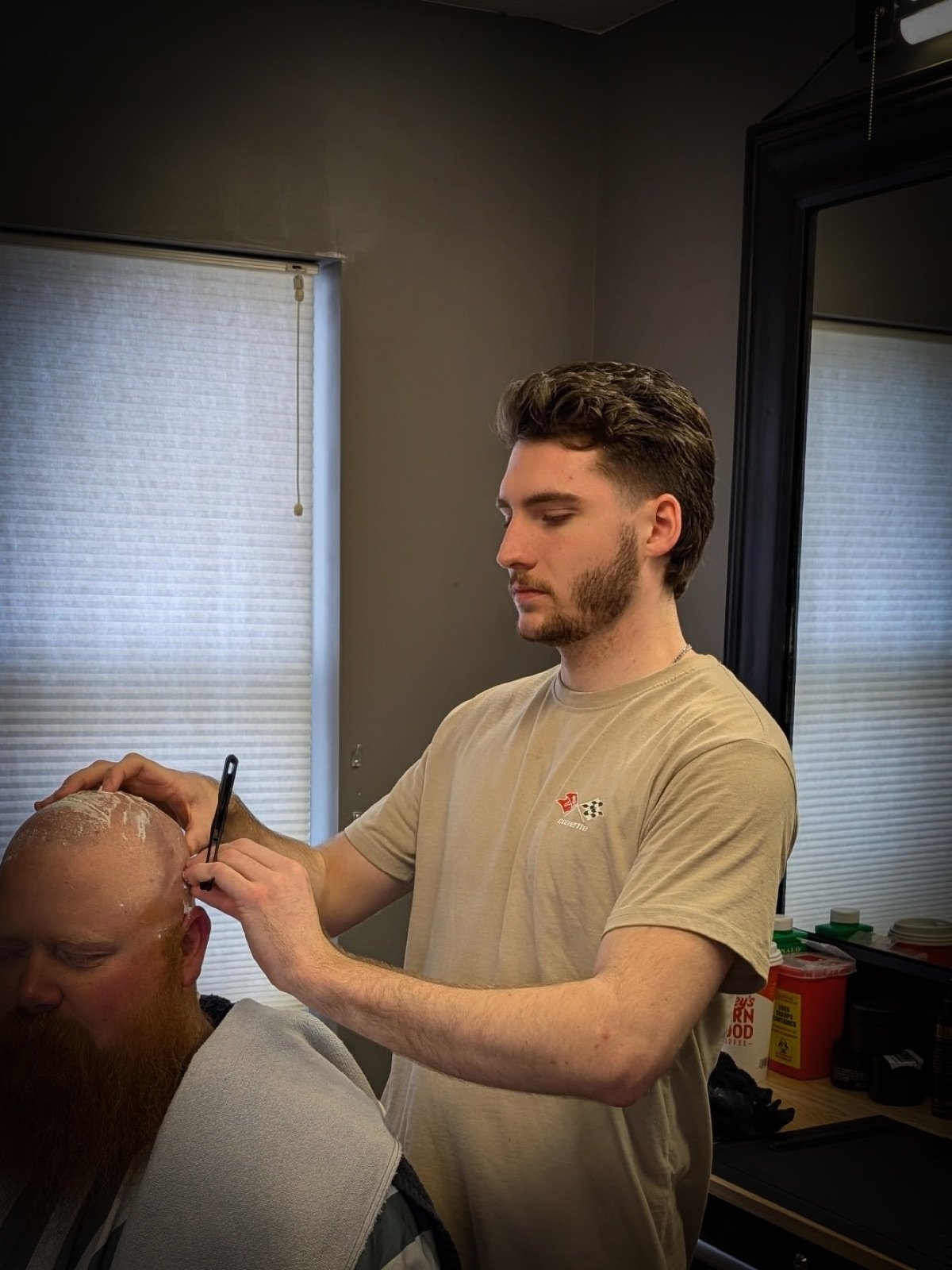 A barber giving a straight razor head shave